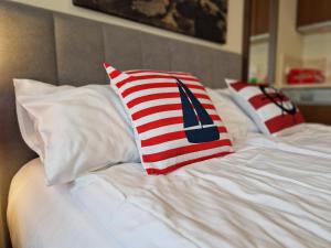 a bed with red white and blue pillows on it at Apartament TRZY POMOSTY Villa Mistral in Świnoujście