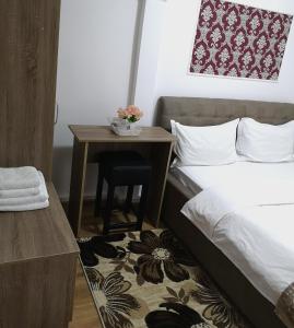 a small room with a bed and a table at Casa Hortensia in Tăşnad