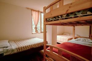 a bedroom with two bunk beds and a window at Backpackers-balcones-river-lodge in Baños