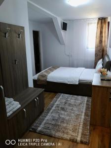 a small bedroom with a bed and a dresser in it at Casa Hortensia in Tăşnad