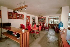 a dining room with a table and red chairs at Backpackers-balcones-river-lodge in Baños