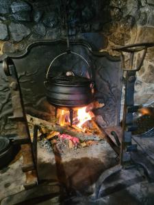 uma panela sobre uma fogueira num forno de pedra em Gite de l'Ours em Saint-Mamet