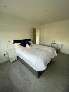 a bedroom with a large white bed with blue pillows at Grey Home Near wembley arena in Wealdstone