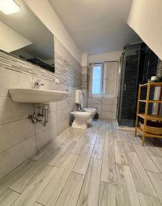 uma casa de banho com um lavatório, um WC e um espelho. em Casa MiRè em Catânia