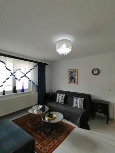 uma sala de estar com um sofá preto e uma mesa em Good Times Apartment em Sarajevo