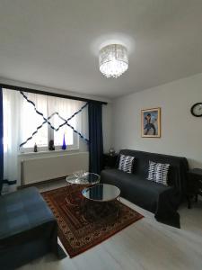 uma sala de estar com um sofá preto e uma mesa em Good Times Apartment em Sarajevo