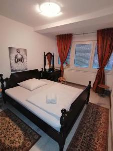 um quarto com uma cama grande num quarto com janelas em Good Times Apartment em Sarajevo