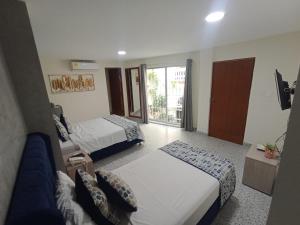 a hotel room with two beds and a couch at Luka Cartagena Hotel in Cartagena de Indias