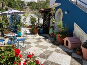 un patio con tavolo, sedie e piante di Liu' e il mare a San Leone