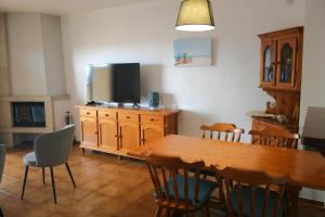 a dining room with a wooden table and a television at Apartamento en primera linea de mar en Pals 306-1 2H in Pals