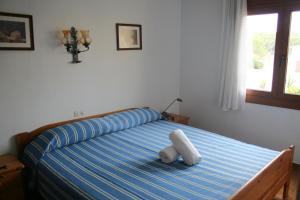 a bedroom with a bed with a blue and blue stripes at Apartamento en primera linea de mar en Pals 306-1 2H in Pals