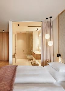 a bedroom with two white beds and a bathroom at Haven Mountain Retreat in Sankt Johann im Pongau