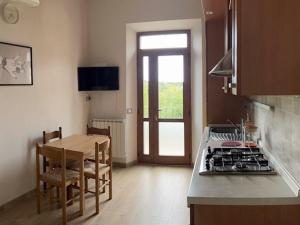 una cucina con piano cottura e tavolo e una cucina con sala da pranzo di Siena Apartment 2 Parcheggio privato e giardino a Siena