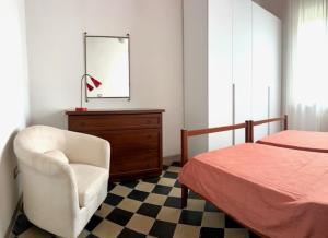 una camera con letto, sedia e cassettiera di Siena Apartment 2 Parcheggio privato e giardino a Siena