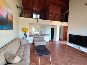 a living room with a couch and a television at Villas EPTA KARPI Complex of 7 Luxury Villas in Skriperón