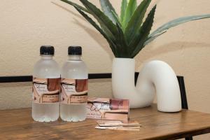 two bottles of water and a vase on a table at The Lavera Guesthouse in Alberton