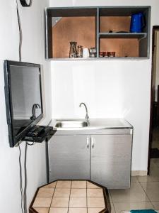 a kitchen with a sink and a tv on a wall at jollof creek in Bathurst