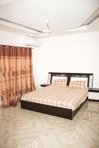 1 dormitorio con 1 cama y ventilador de techo en jollof creek, en Banjul