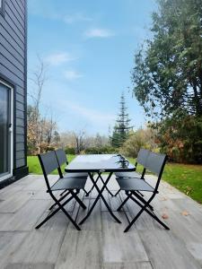 a picnic table and two chairs on a patio at Condo sur 2 étages in Saint-Faustin