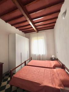 una camera da letto con un letto con lenzuola arancioni e una finestra di Siena Apartment 2 Parcheggio privato e giardino a Siena