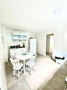 cocina con mesa blanca y sillas en una habitación en Cobertura com Piscina Andrei Noriller Vista Mar, en Arraial do Cabo