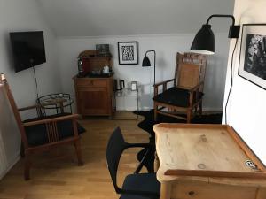 a living room with chairs and a table and a tv at Bed and Breakfast The Old Chestnut Tree Silkeborg in Silkeborg