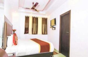 Schlafzimmer mit einem Bett und einem Deckenventilator in der Unterkunft Hotel Living Rooms- BY Hotel Green Snapper in Neu-Delhi