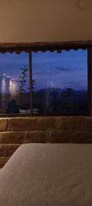 a bedroom with a bed and a window with a view at Hospedaje Leonor in Cuenca