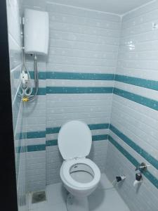 uma casa de banho com um WC com riscas azuis e brancas em Kishan Kanhaiya Homestay em Garudeshwar