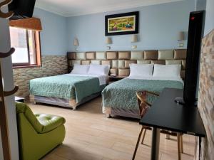 une chambre d'hôtel avec deux lits et une chaise dans l'établissement Hotel Tinkus Inn, à Lima