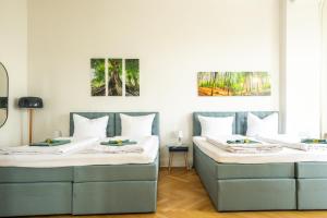 dwa łóżka siedzące obok siebie w pokoju w obiekcie K132 bis 10 Personen 155 sqm 3 Bedrooms 2 Bathrooms 2OG Aufzug 2 Balkone Boxspringbetten w Berlinie