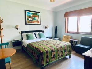 - une chambre avec un lit, une table et une chaise dans l'établissement Hotel Tinkus Inn, à Lima