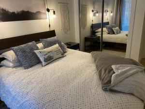 a bedroom with a bed with pillows and a mirror at Cozy Townhouse in Whistler Village North in Whistler +22 photos