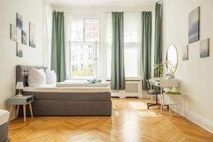 ベルリンにあるKAISER 02 by ROCKCHAIR Apartments l SUPERHOST Status l 3 Bedrooms Boxspringbeds 2 Bathrooms l Cozy Family & Business Flair 155 sqm 3 Balcony 2nd Floor Elevator up to 10 guests welcomes you!のベッドルーム1室(ベッド1台、窓、デスク付)