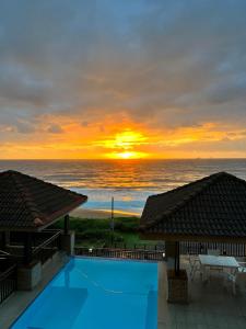 puesta de sol sobre el océano desde un complejo con piscina en Bali Hai, en Westbrook