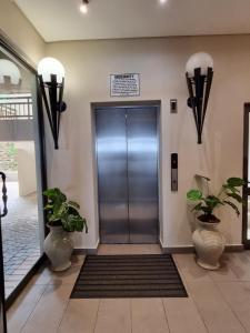 an elevator in a building with two potted plants at Bali Hai in Westbrook
