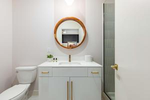 a white bathroom with a sink and a mirror at Outrider Buyout- 3 units by AvantStay Sleeps 30 in Nashville