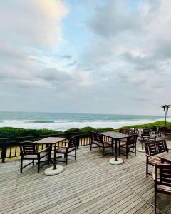 una terraza con mesas y sillas y el océano en Bali Hai, en Westbrook