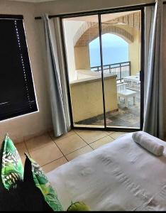 a bedroom with a view of the ocean from a balcony at Bali Hai in Westbrook +34 photos