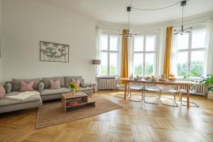 ベルリンにあるKAISER 02 by ROCKCHAIR Apartments l SUPERHOST Status l 3 Bedrooms Boxspringbeds 2 Bathrooms l Cozy Family & Business Flair 155 sqm 3 Balcony 2nd Floor Elevator up to 10 guests welcomes you!のソファとテーブルのあるリビングルーム