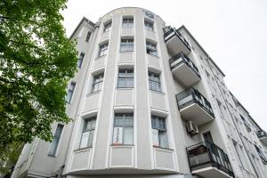ベルリンにあるKAISER 02 by ROCKCHAIR Apartments l SUPERHOST Status l 3 Bedrooms Boxspringbeds 2 Bathrooms l Cozy Family & Business Flair 155 sqm 3 Balcony 2nd Floor Elevator up to 10 guests welcomes you!の看板のある白い建物