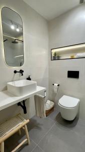 ein Badezimmer mit einem Waschbecken, einem WC und einem Spiegel in der Unterkunft Estilosa casa golf in Gorraiz