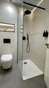 uma casa de banho com um WC e uma cabina de duche em vidro. em Estilosa casa golf em Gorraiz