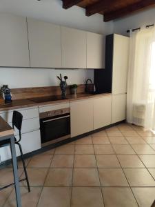 a kitchen with white cabinets and a black oven at Casa An'anasha in Luino +21 photos