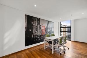 un bureau avec une table, des chaises et un grand tableau dans l'établissement FH - Spectacular studio in Chico - Bogota, à Bogotá