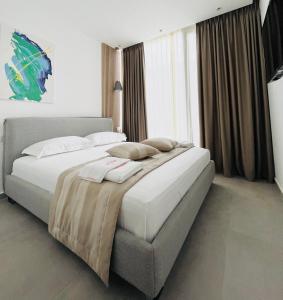 a bedroom with two beds and a large window at Vesper Suites in Dhërmi