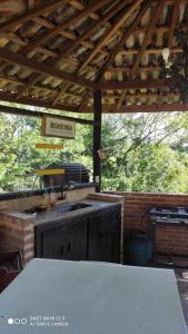 a kitchen under a wooden roof with a sink at Challet do Fabio Mirante Pousada in Santo Antônio do Pinhal