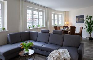 uma sala de estar com um sofá azul e uma mesa em Stadtoase am Doberaner Platz New6Pers em Rostock