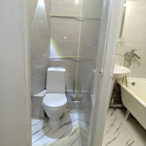 ein Badezimmer mit einem weißen WC und einem Waschbecken in der Unterkunft Квартира трехкомнатная в Орбите 3 на первом этаже in Almaty