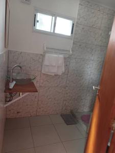 a bathroom with a shower with a sink and a window at Casa 2 pisos Para 5 personas toda equipada in Colonia del Sacramento